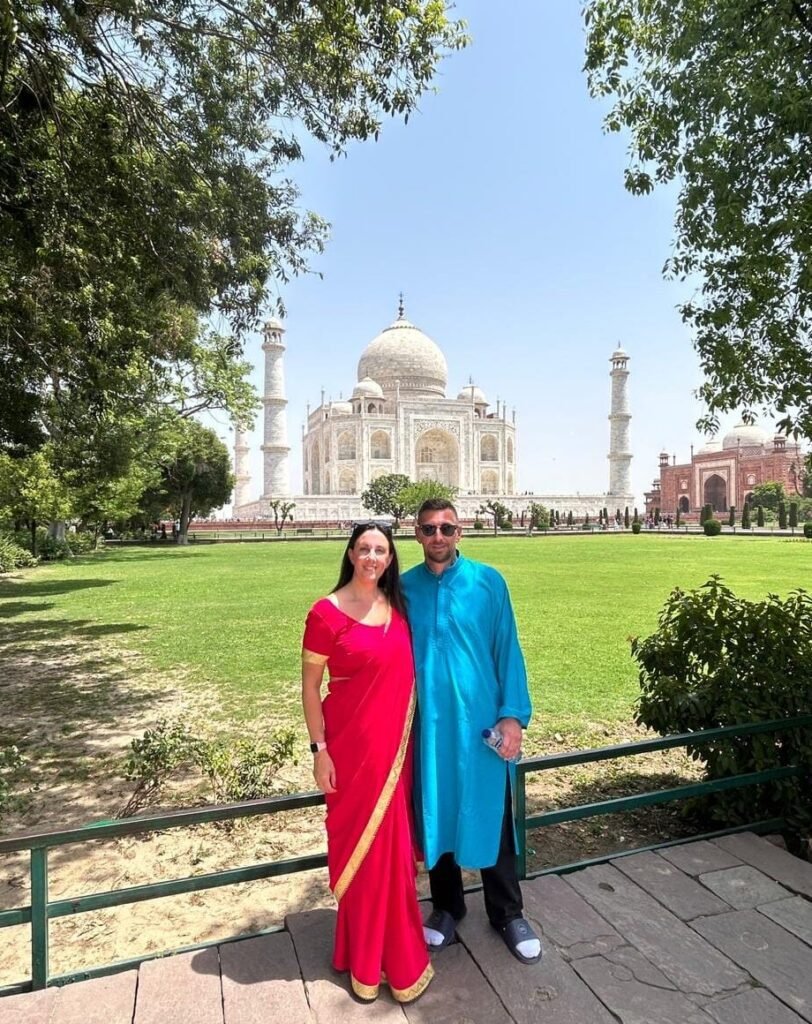 Travellers posing in traditional Indian attire with the Taj Mahal in Agra during a Same Day Agra Tour